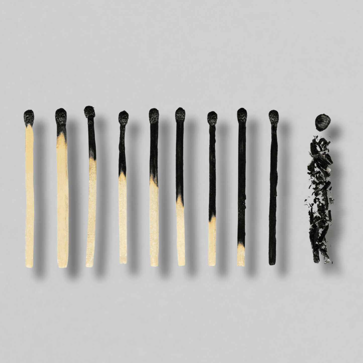 Matches with varying degrees of burning on a gray background