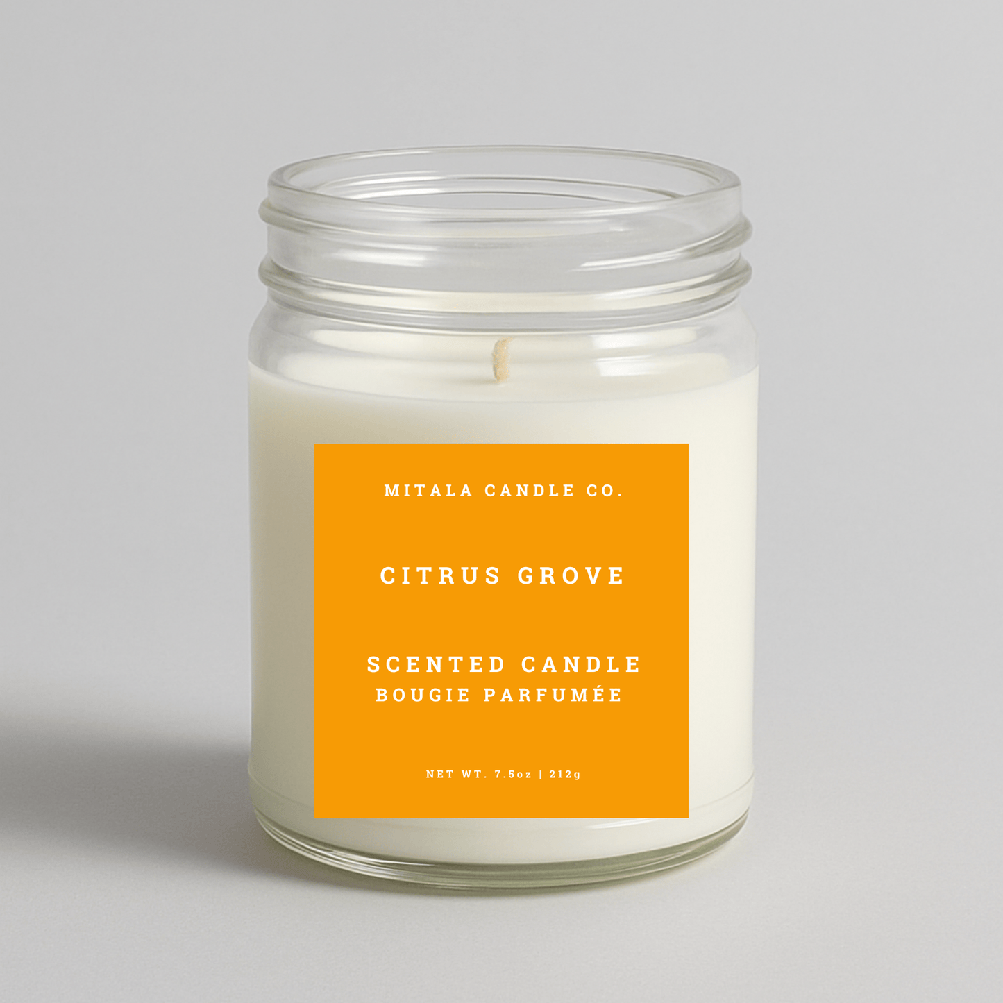 Mitala Candle Co. Citrus Grove scented candle with an orange label on a light gray background