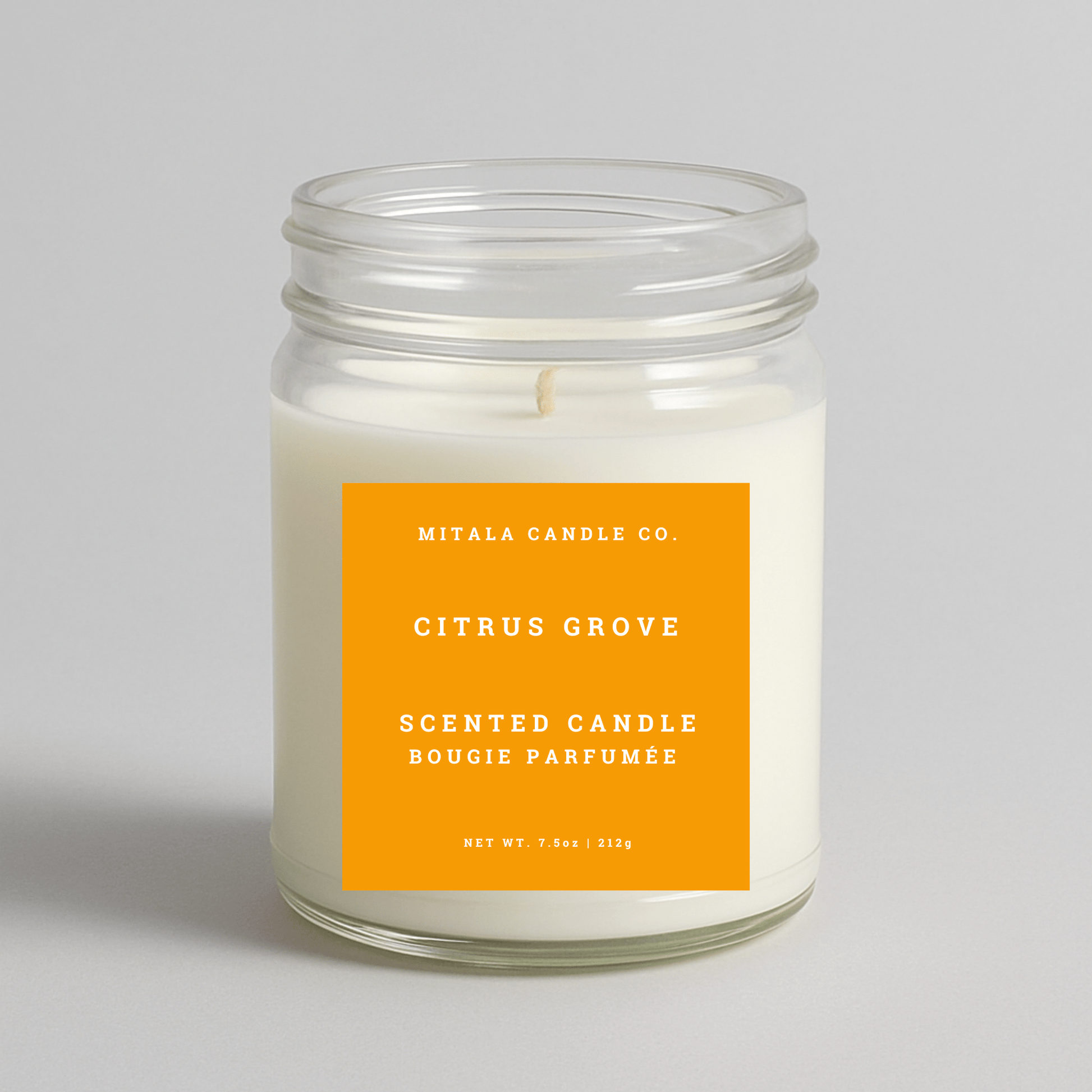 Mitala Candle Co. Citrus Grove scented candle with an orange label on a light gray background