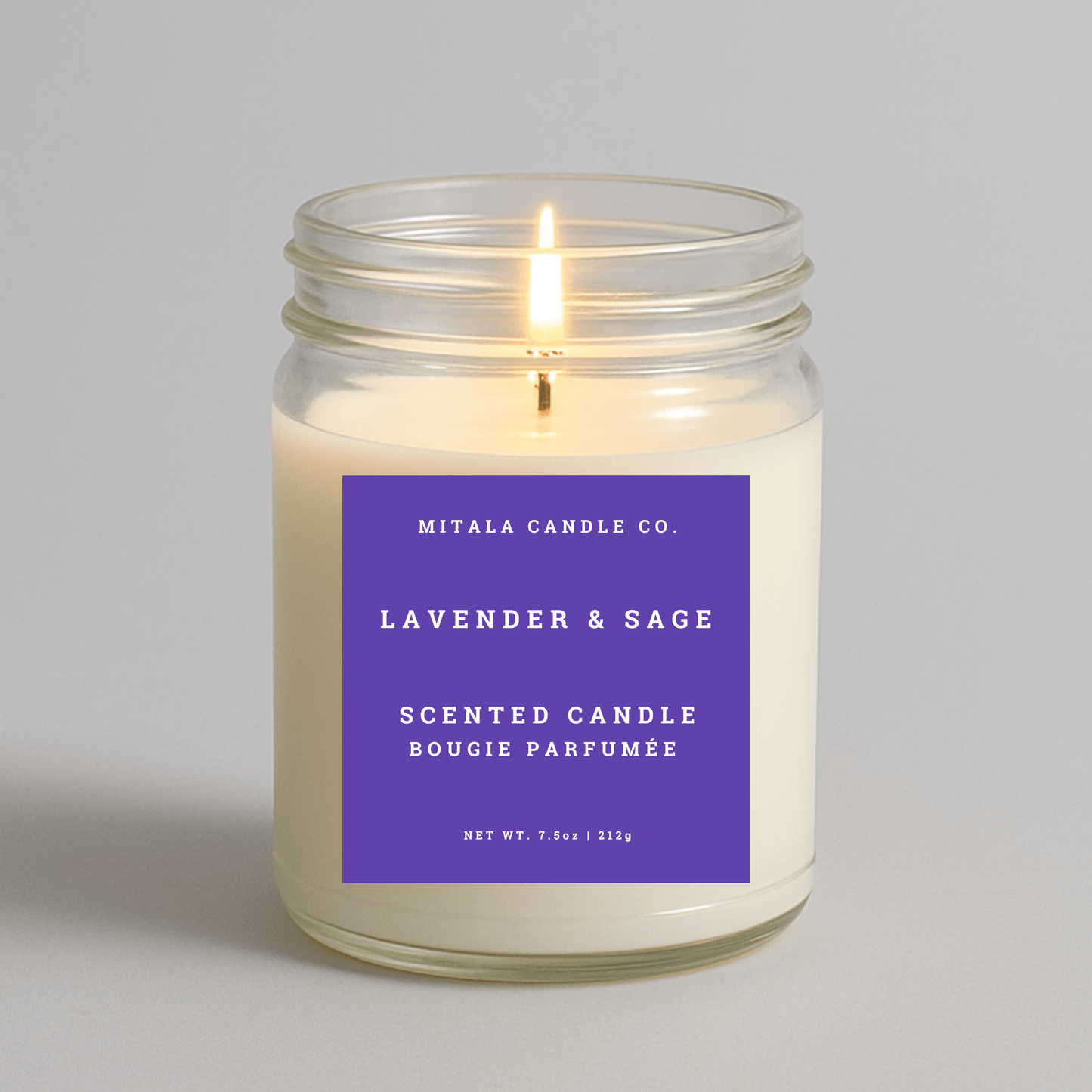 Mitala Candle Co. lavender & sage scented candle with a purple label on a gray background