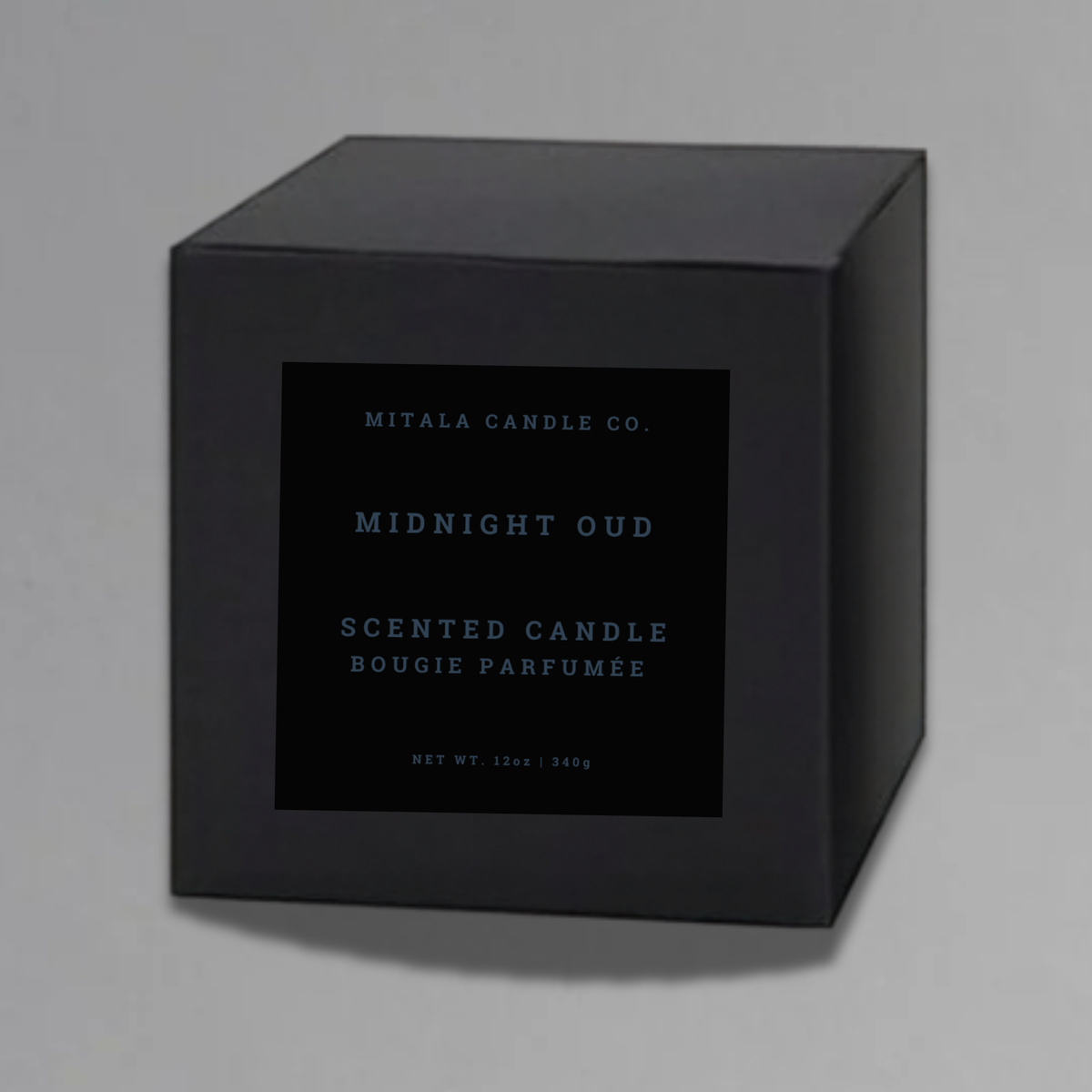 Luxury 12oz soy candle 'Midnight Out' by Mitala Candle Co. next to white gift box on gray background