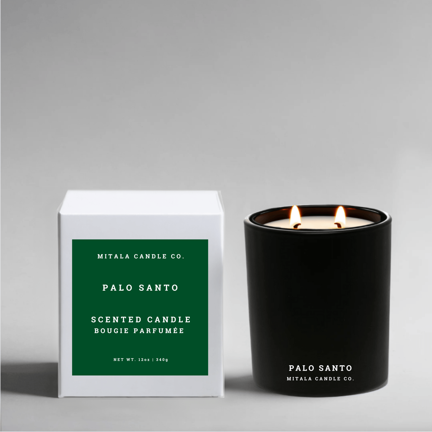 Eco-luxury soy black candle with 'Palo Santo' branding next to its white gift box on a gray background