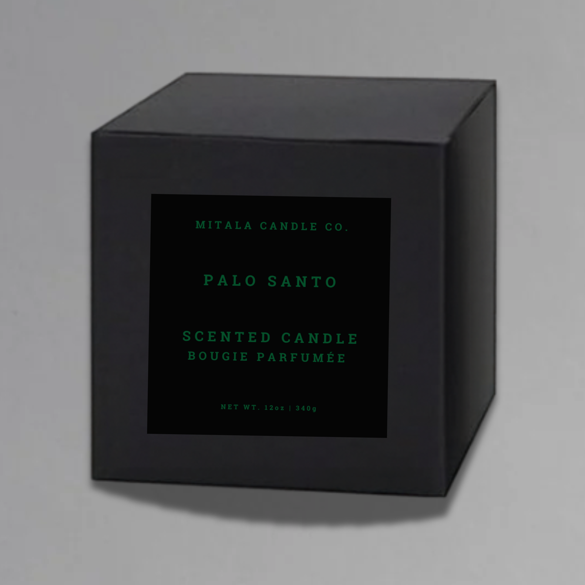 Luxury 12oz soy candle 'Palo Santo' by Mitala Candle Co. next to white gift box on gray background