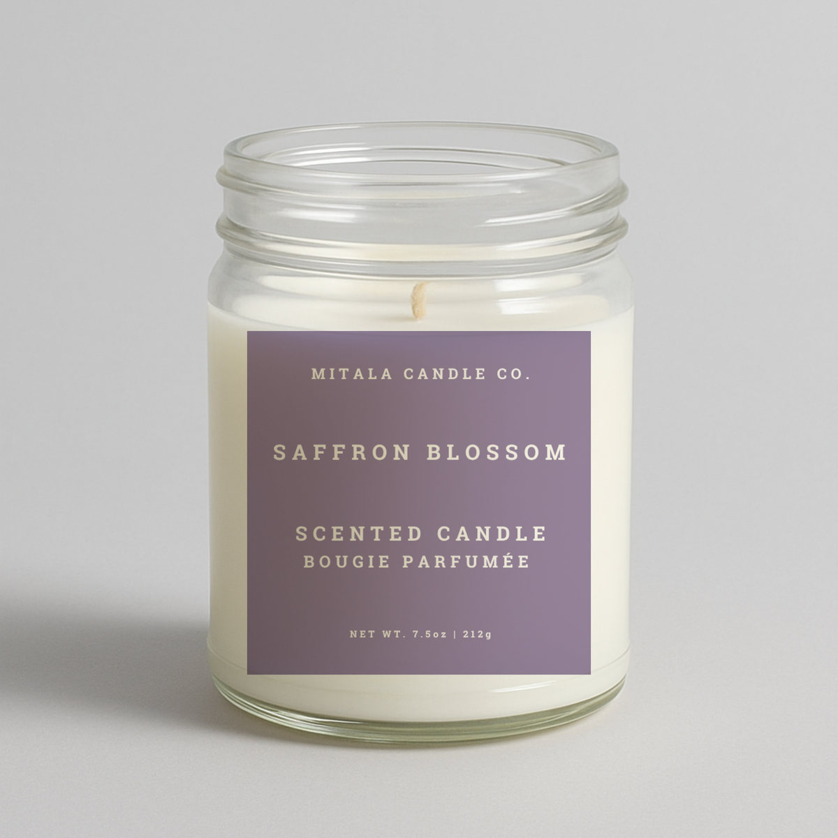Mitala Candle Co. Saffron Blossom scented candle in glass jar with purple label, 7.5oz, on light gray background