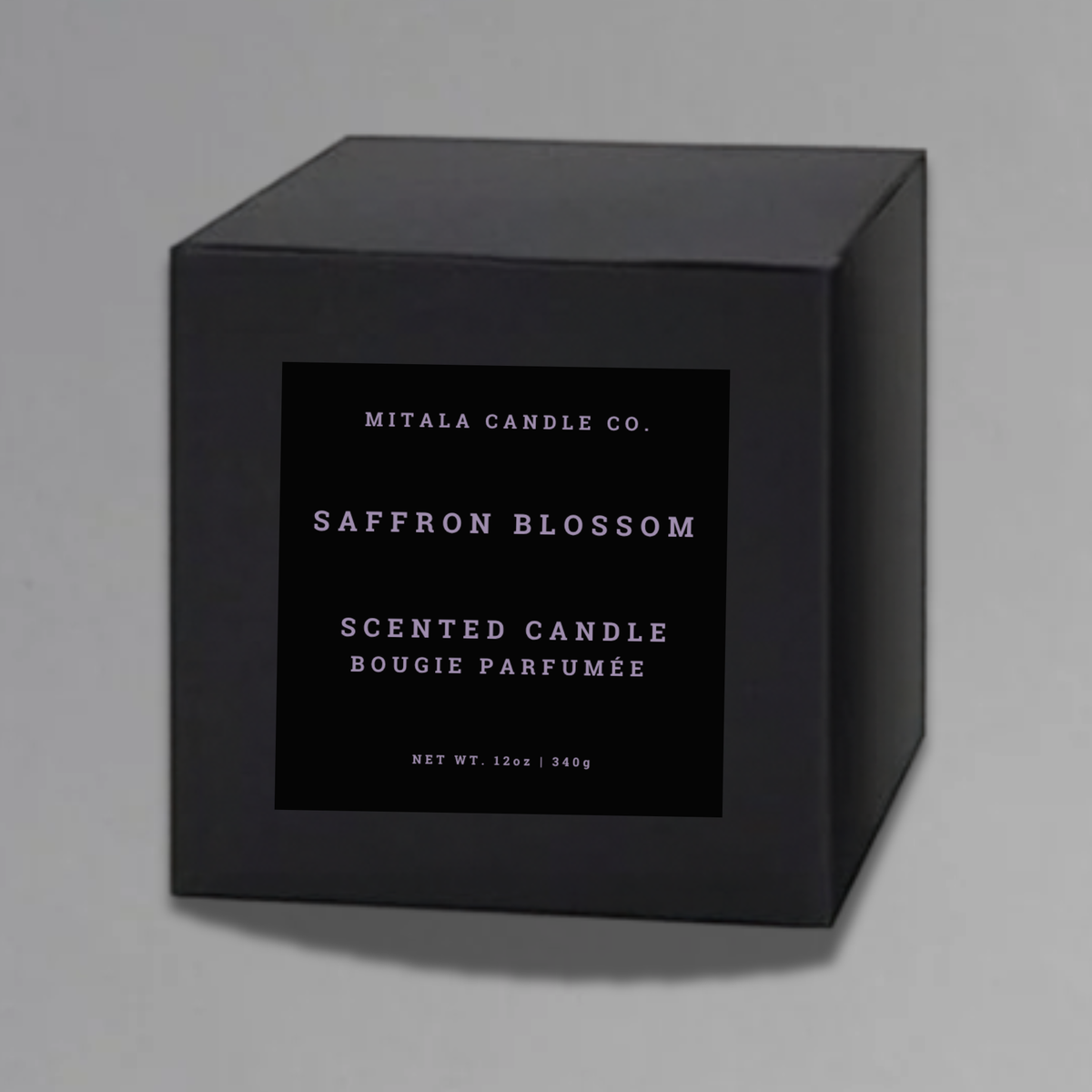 Luxury 12oz soy candle 'Saffron Blossom' by Mitala Candle Co. next to white gift box on gray background