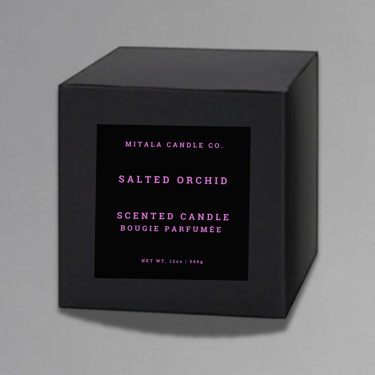 Luxury 12oz soy candle 'Salted Orchid' by Mitala Candle Co. next to white gift box on gray background