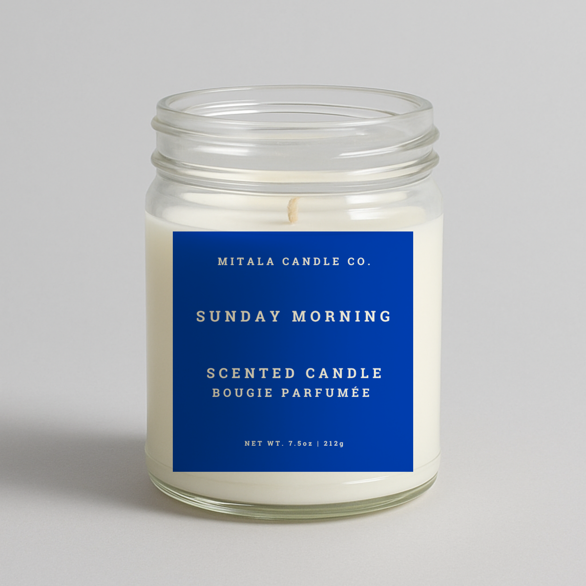 Mitala Candle Co. Sunday Morning scented candle with blue label, 7.5oz, on gray background
