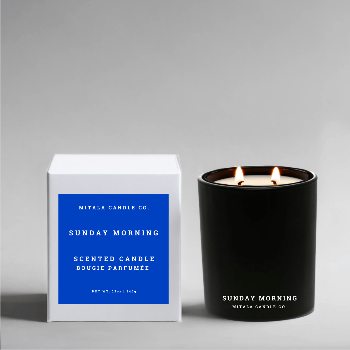 Luxury soy candle in scent 'Sunday Morning' next to its white gift box on a gray background