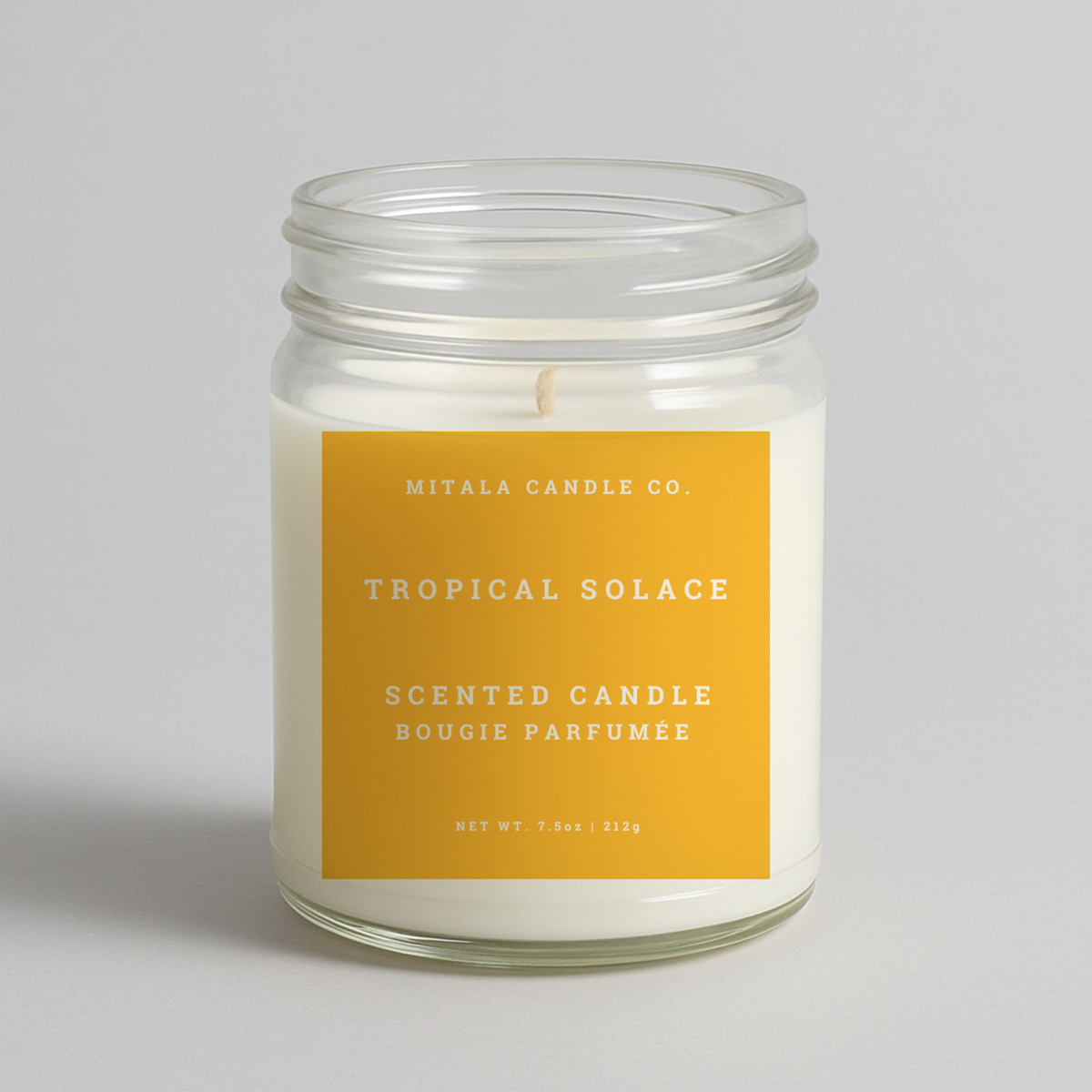 Mitala Candle Co. Tropical Solace scented candle with yellow label, 7.5oz, on light gray background