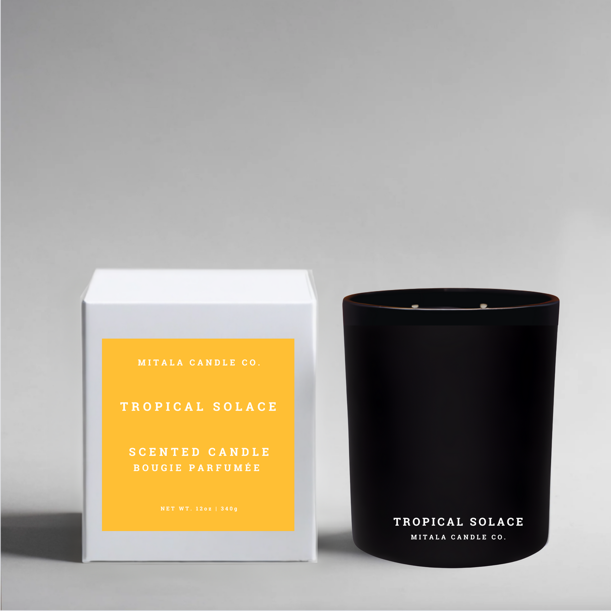 Luxury soy wax candle labeled 'Tropical Solace' with a white gift box featuring a yellow label on a gray background