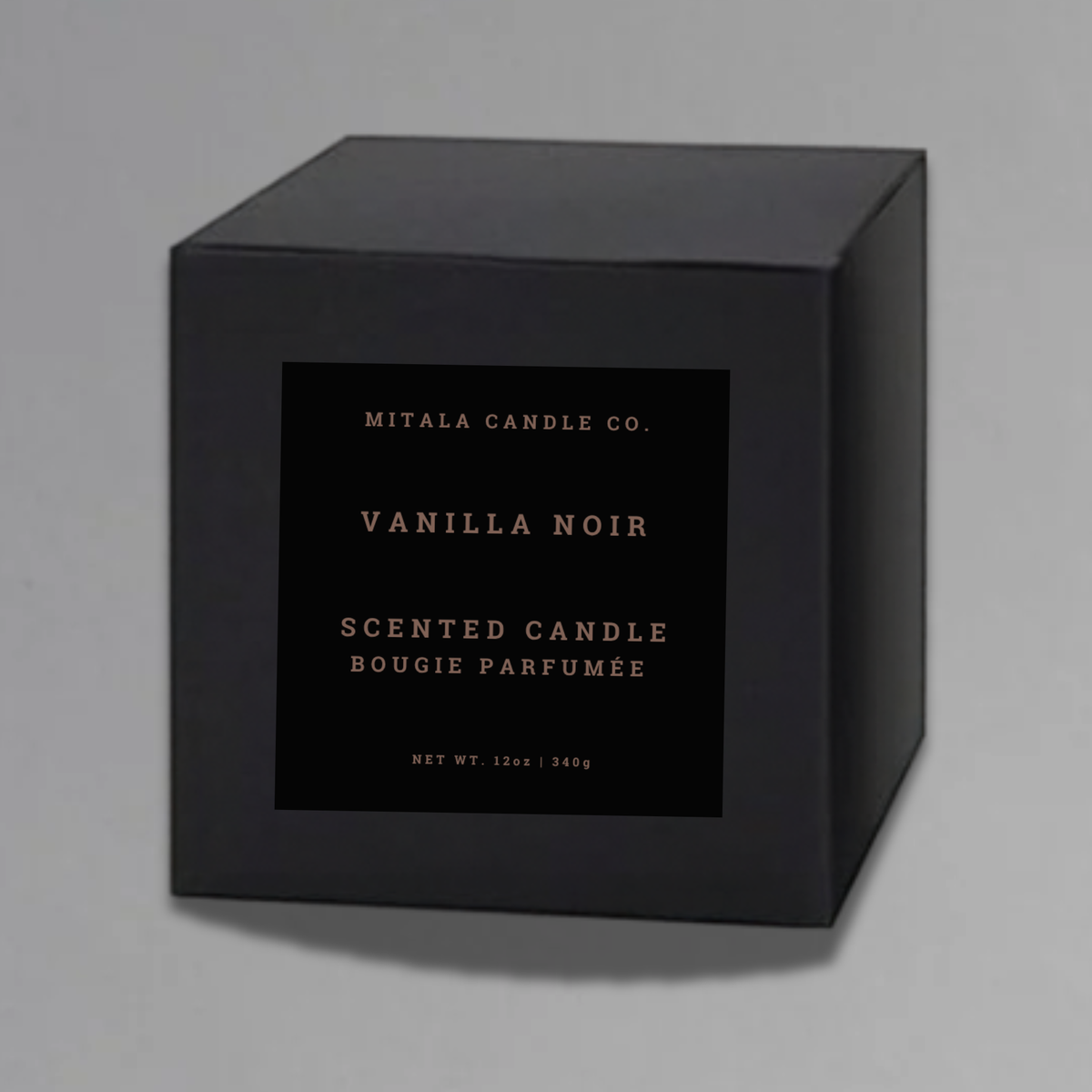Luxury 12oz soy candle 'Vanilla Noir' by Mitala Candle Co. next to white gift box on gray background