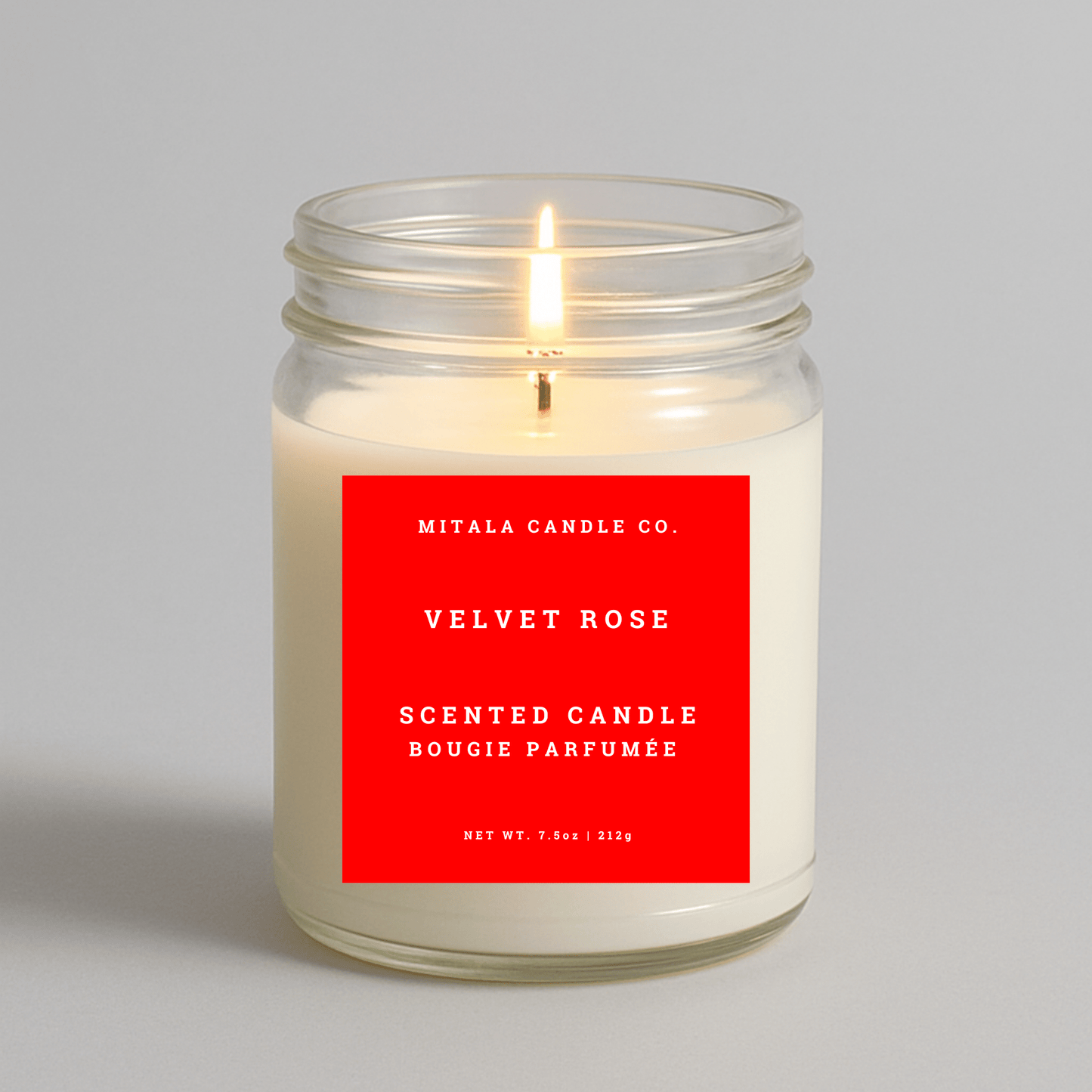 Mitala Candle Co. Velvet Rose scented candle with a red label on a gray background