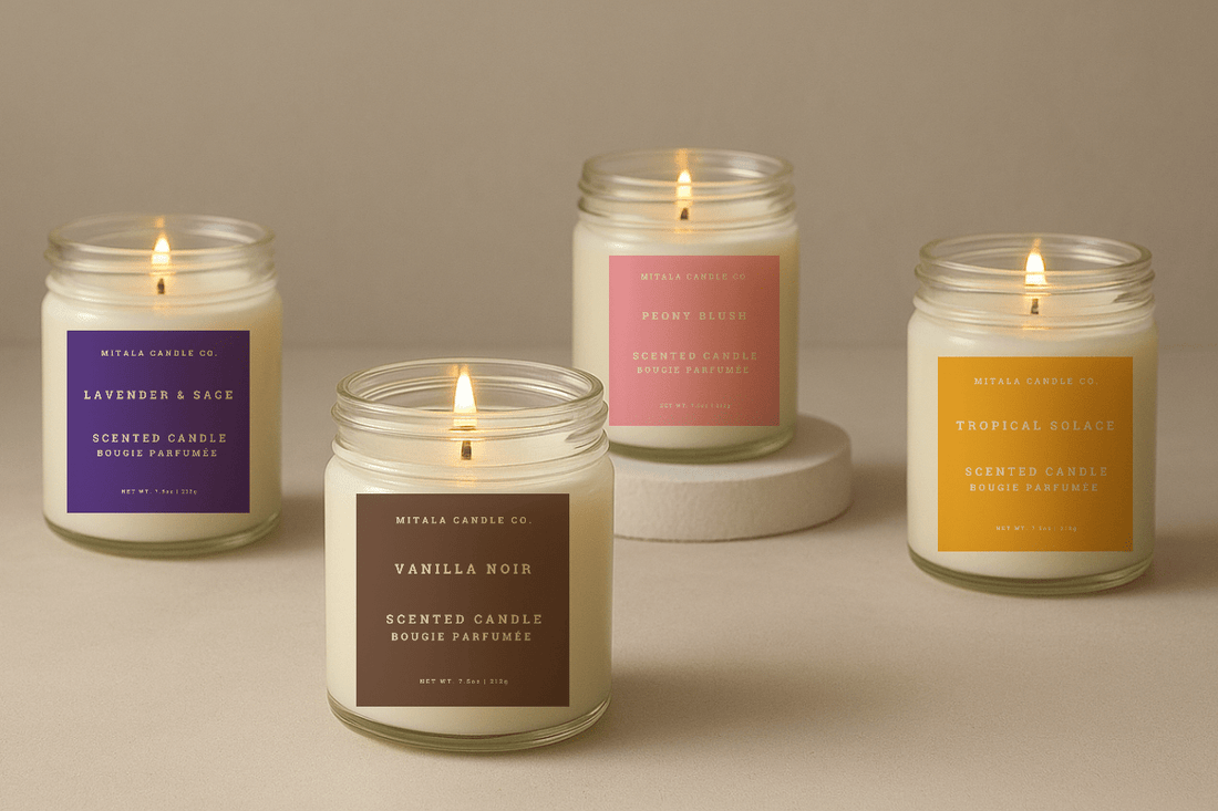 Four scented Mitala Candle Co. candles in jars with vibrant labels, lit and arranged on a neutral surface, creating a cozy ambiance.