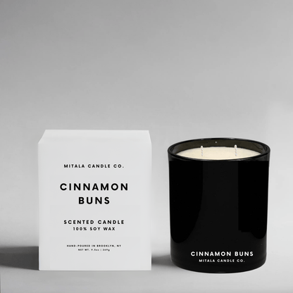 Mitala Candle Co. luxury Cinnamon Buns soy wax candle in a sleek black glass jar with a crisp white gift box, ideal for gifting.