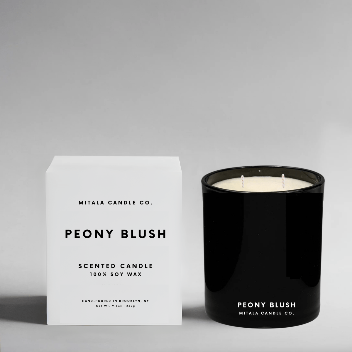 Mitala Candle Co. luxury Peony Blush soy wax candle in a sleek black glass jar with a crisp white gift box, ideal for gifting.