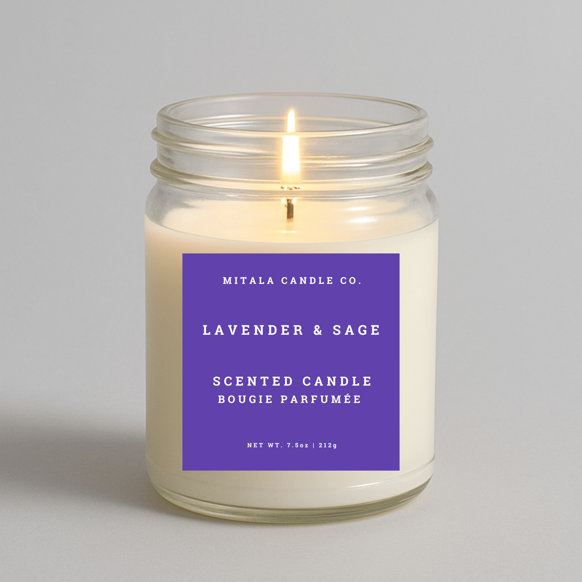 Mitala Candle Co. lavender & sage scented candle with a purple label on a gray background