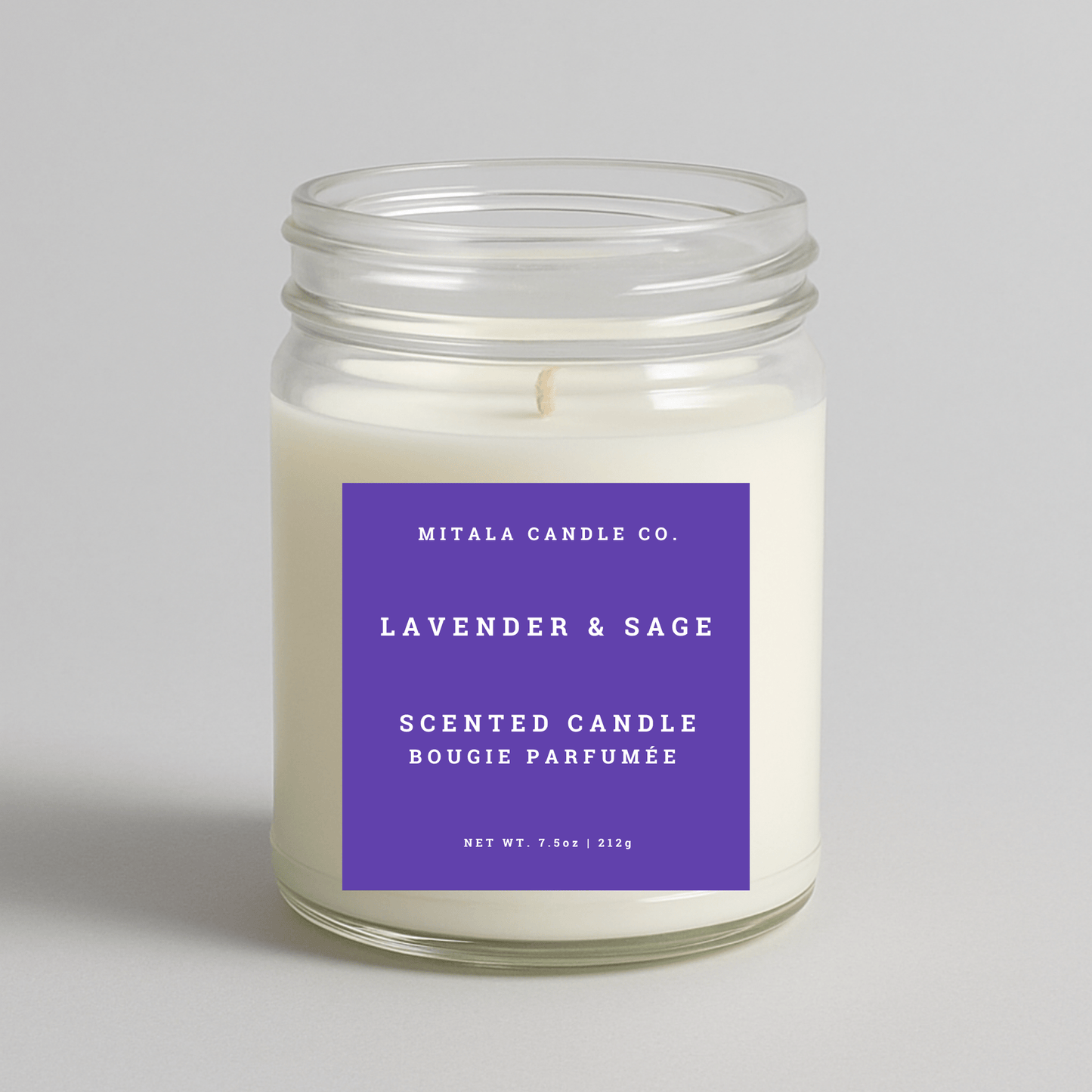 Mitala Candle Co. lavender & sage scented candle with a purple label on a light gray background