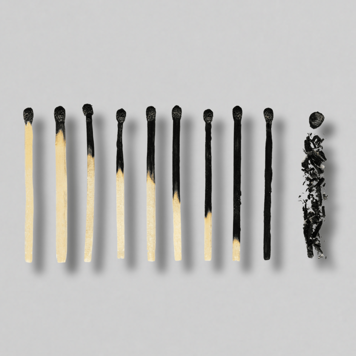 Matches with varying flame heights on gray background, ideal for candle lighting, home decor, or cozy ambiance