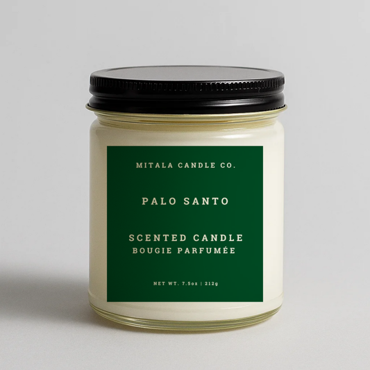 Mitala Candle Co. Palo Santo scented candle with green label and black lid, 7.5oz, on light gray background