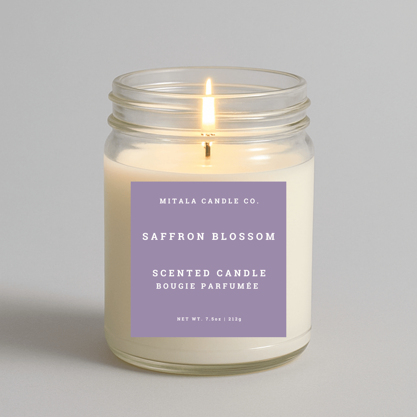 Mitala Candle Co. saffron blossom scented candle with a purple label on a gray background