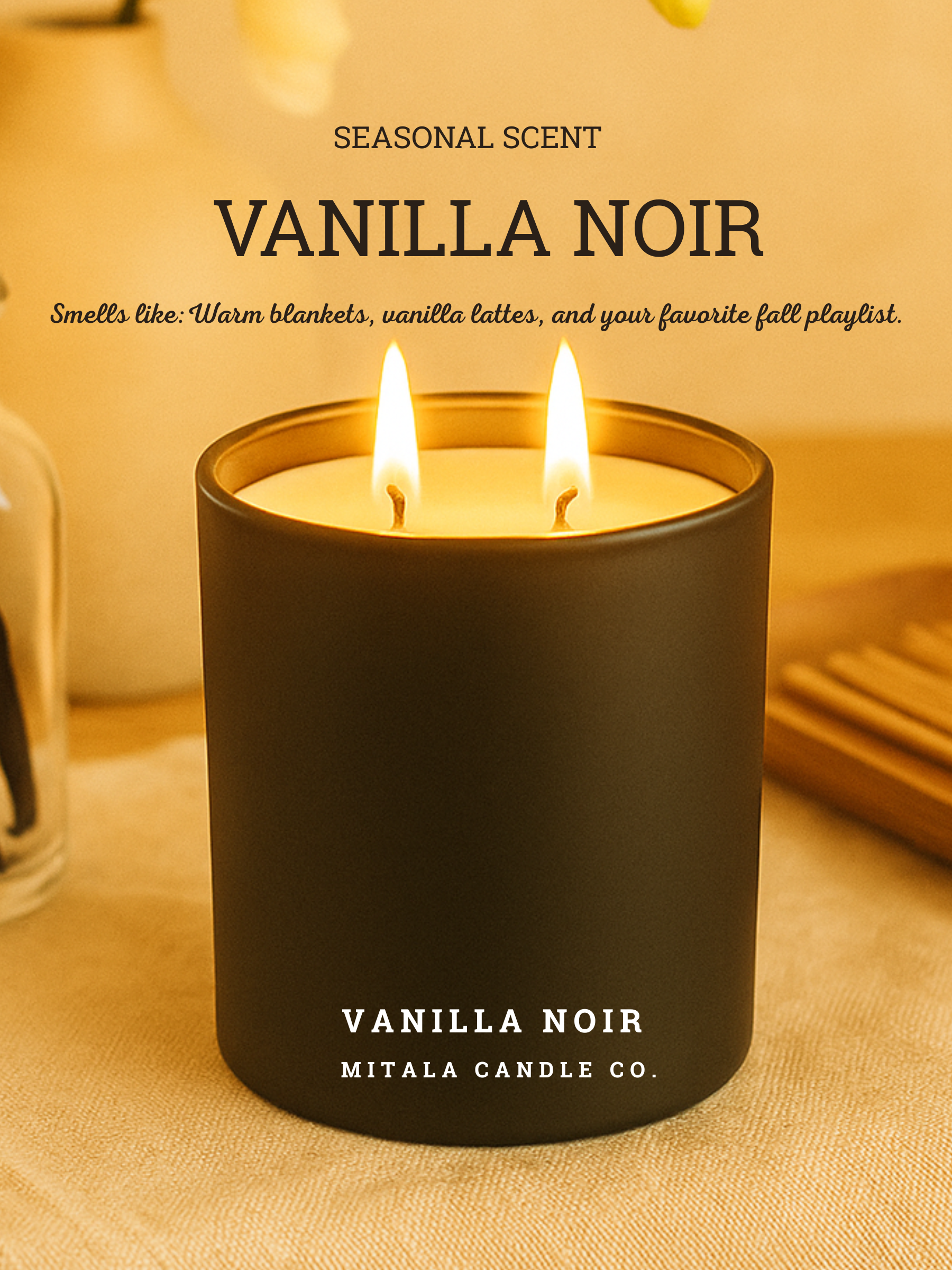 A Mitala Candle Co. candle  in a black jar labeled "Vanilla Noir" is lit on a wooden table beside a jar with sticks and an open book. The scene is warm and inviting. Text reads: "Seasonal Scent, Vanilla Noir. Smells like: Warm blankets, vanilla lattes, and your favorite fall playlist."