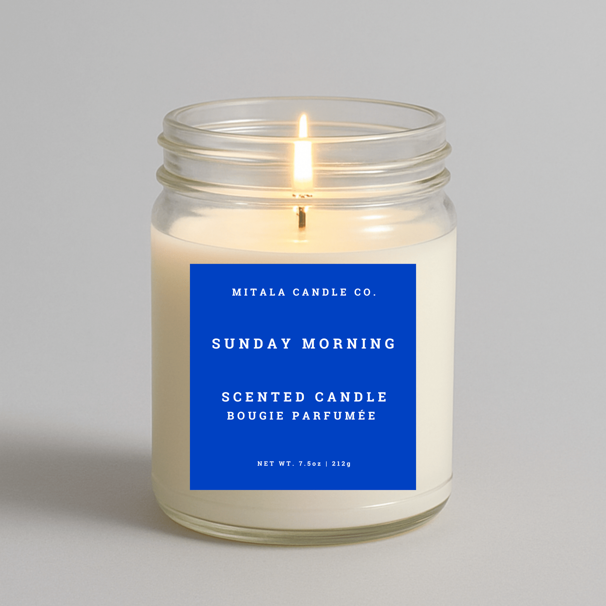 Mitala Candle Co. Sunday Morning scented candle with a blue label on a gray background