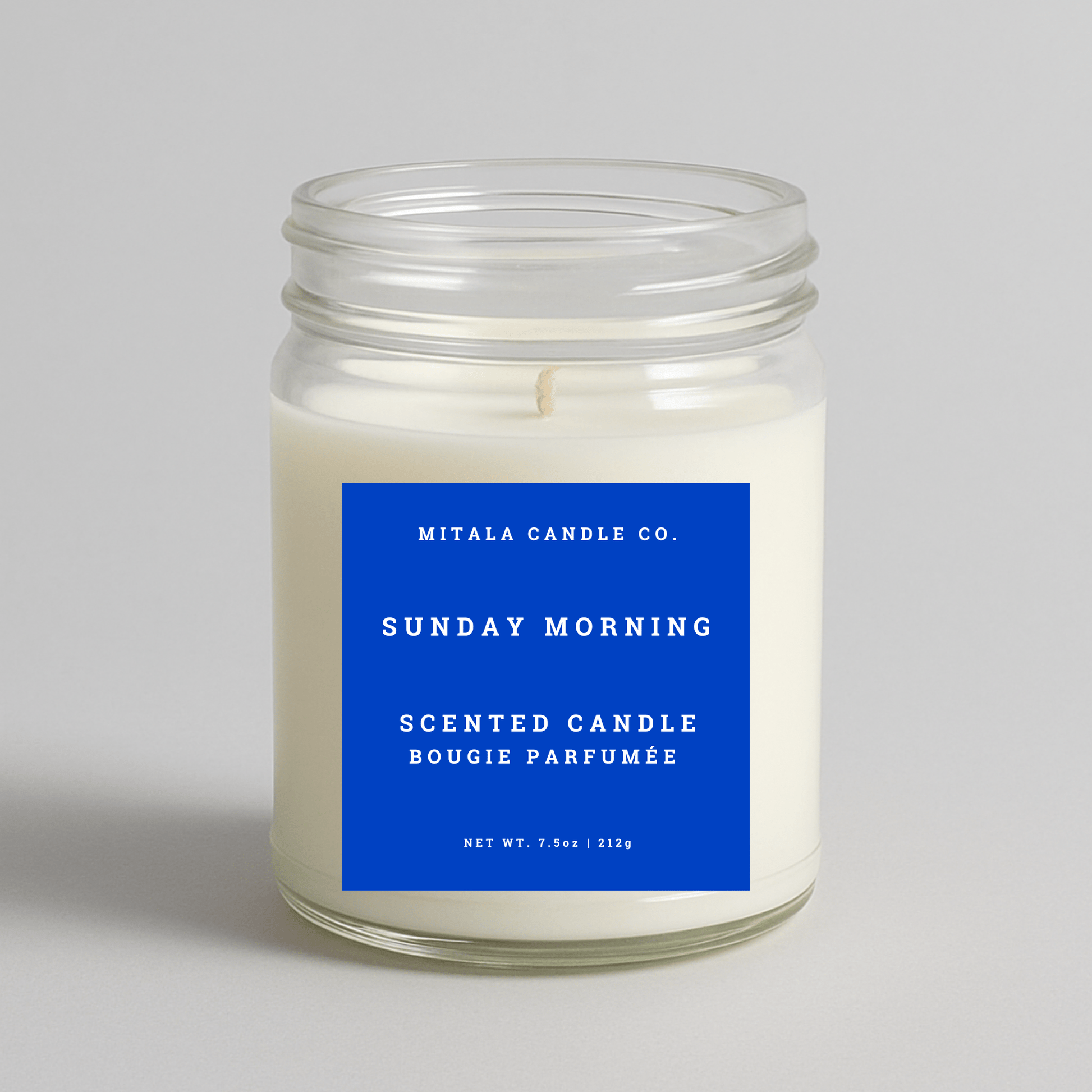 Mitala Candle Co. Sunday Morning scented candle with a blue label on a gray background