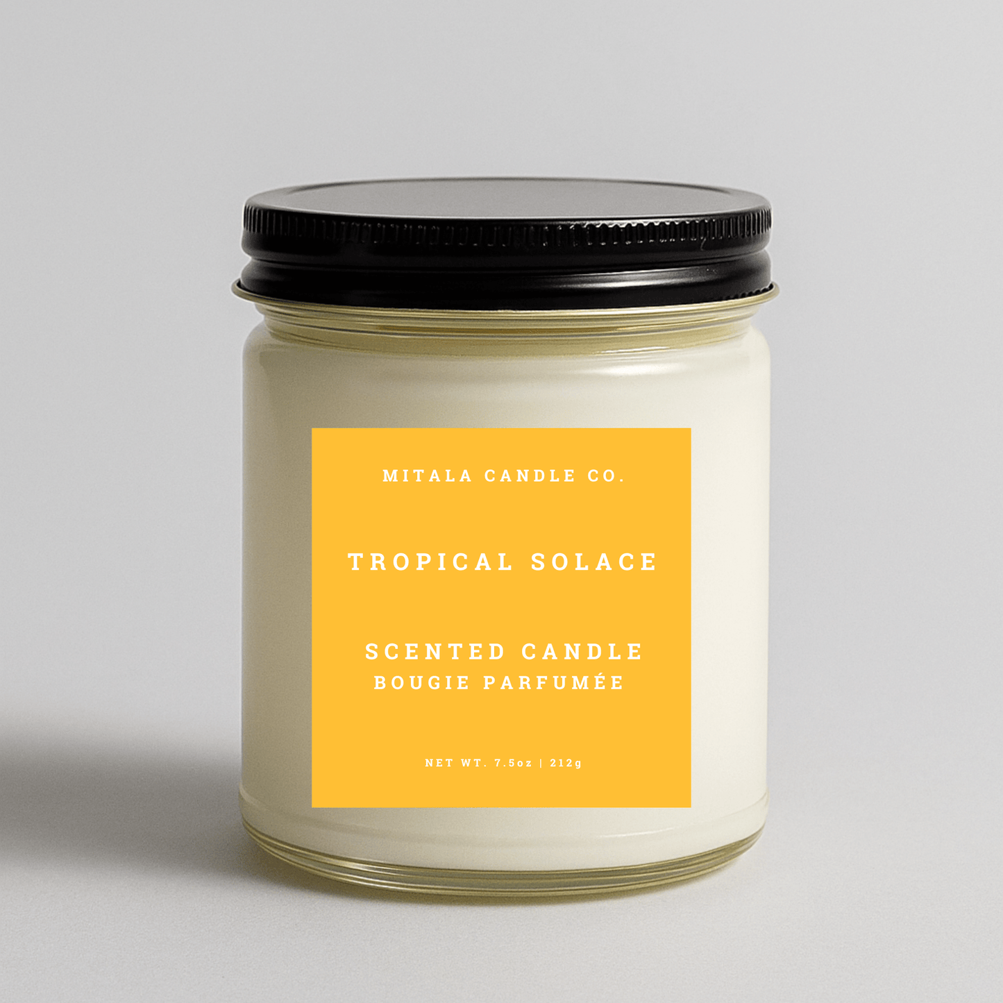 Mitala Candle Co. Tropical Solace candle with yellow label and black lid, 7.5oz, gray background