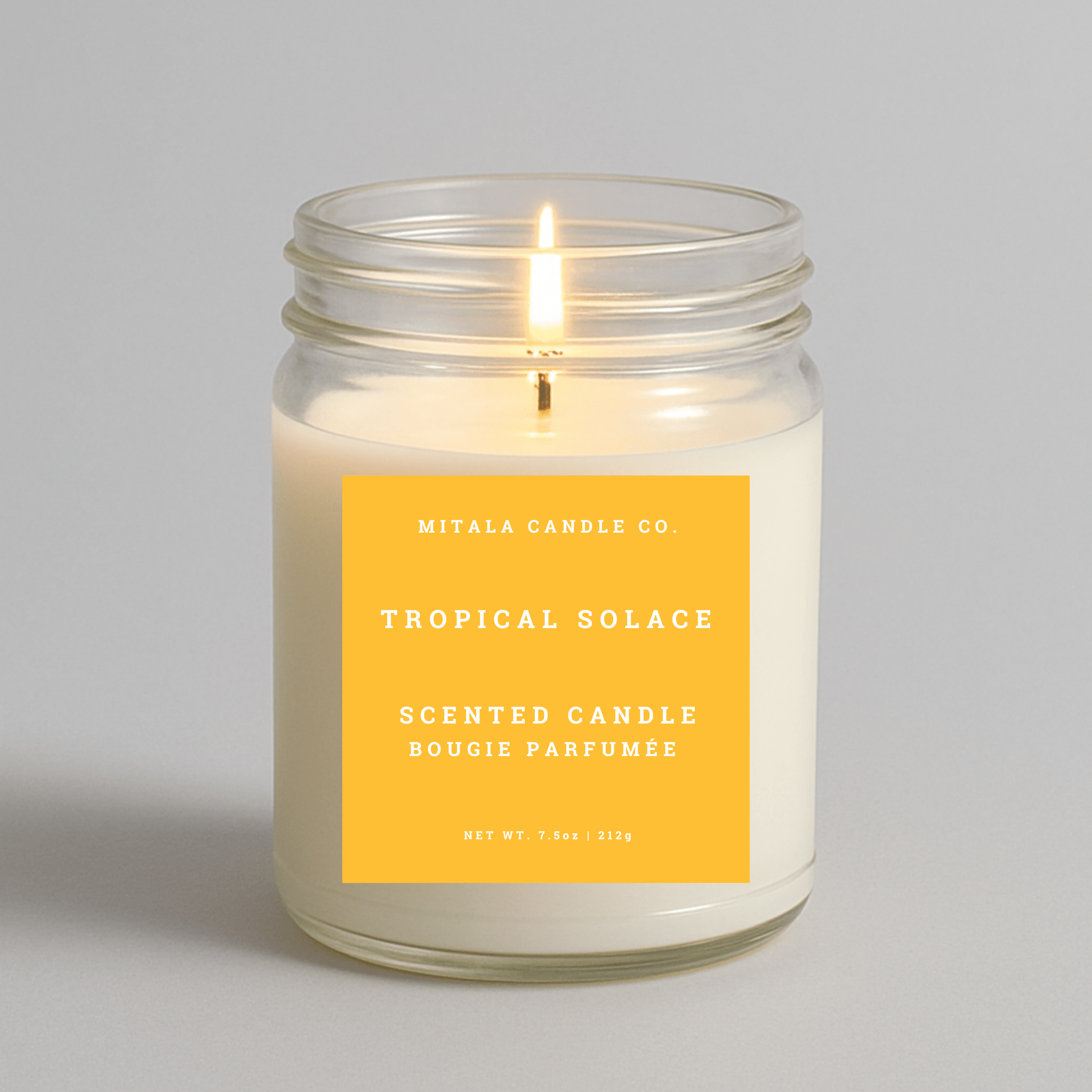 7.5oz Tropical Solace scented candle by Mitala Candle Co. with yellow label, perfect for gifts or home decor
