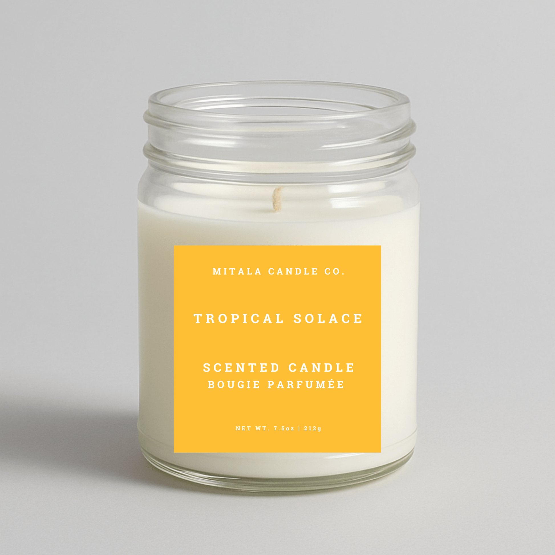 Mitala Candle Co. Tropical Solace scented candle with a yellow label on a light gray background